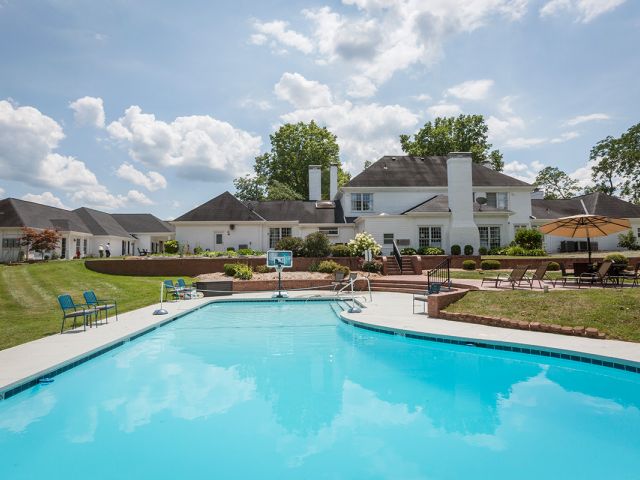 a swimming pool with a basketball hoop in the back